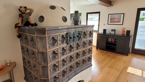 Una cocina moderna con estufa integrada, piso de madera y un mueble oscuro decorado con azulejos.
