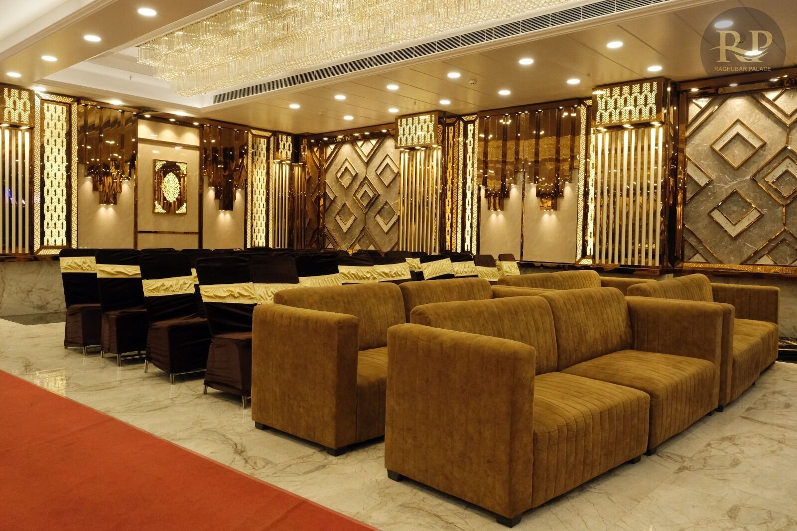 A luxurious lobby with plush seating, decorative wall panels, and a chandelier.