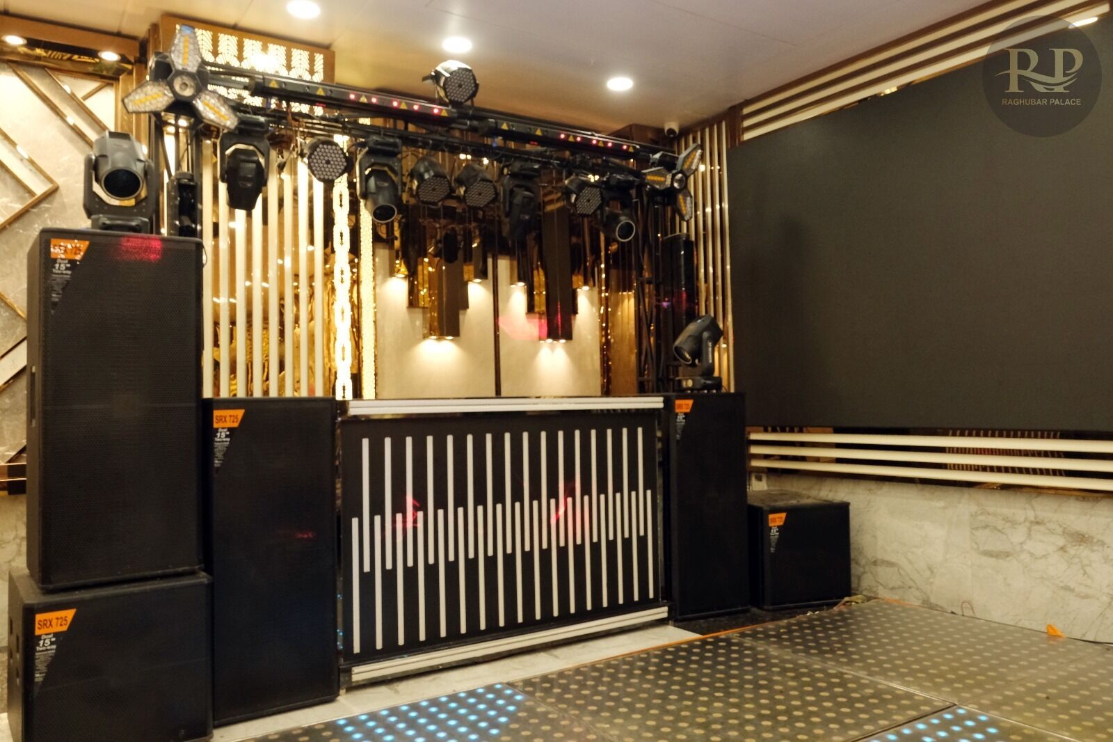 A theater with a stage, lighting equipment, and speakers.