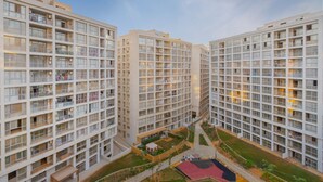 Un immeuble résidentiel de grande hauteur, doté de nombreux balcons et d’une cour intérieure.