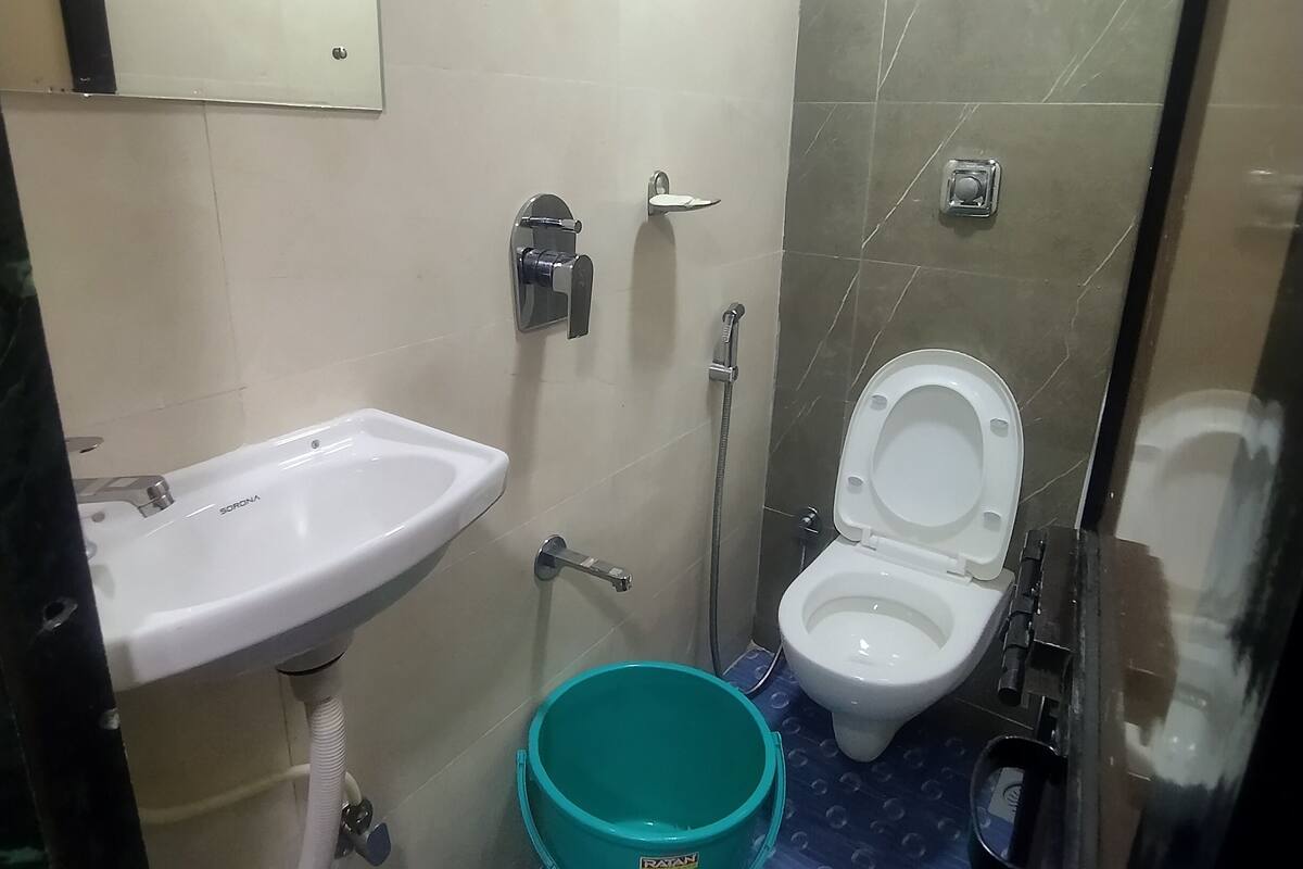 A small bathroom with a sink, toilet, and shower.