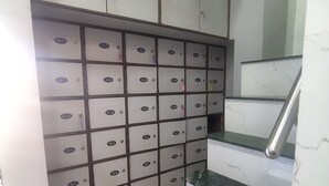 Uma escadaria com degraus de mármore e uma parede com caixas organizadoras identificadas de A-1 a B-20.
