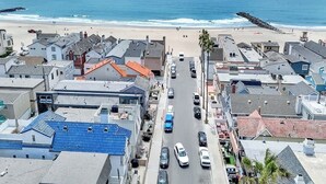 A coastal town with a main road, beach, and residential buildings. - 117 31st St A | Stylish Renovation w/ Large Patio Steps To Sand (Newport Beach)