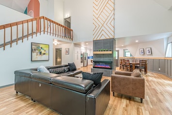 Living room has high ceilings and a fireplace