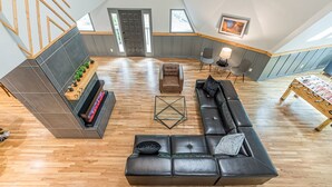 Un loft amplio con una decoración moderna, que incluye un sofá de cuero negro, una mesa de centro de madera y una chimenea.