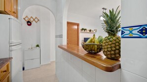 A kitchen with white cabinets, a wooden countertop, and a door leading to another room. - 150m from the beach, 3-bedroom apartment with nice living room and office area (Torrevieja)