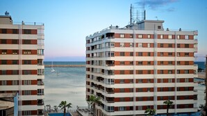 A multi-story hotel with balconies, a swimming pool, and a view of the sea. - 150m from the beach, 3-bedroom apartment with nice living room and office area (Torrevieja)