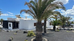 A modern building with a white facade, satellite dishes, and a palm tree in the foreground. - Villa Blanca 2, FKK - Lanzarote, Charco del Palo, Schönes Schwimmbad (Charco del Palo)