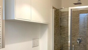 Un baño moderno con ducha, inodoro y lavabo.