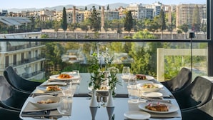A dining table set for two with a view of a cityscape. - The Athenaeum Luxury Hotel (Athens)