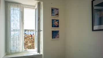 Una habitación con ventana, un radiador y tres cuadros en la pared.