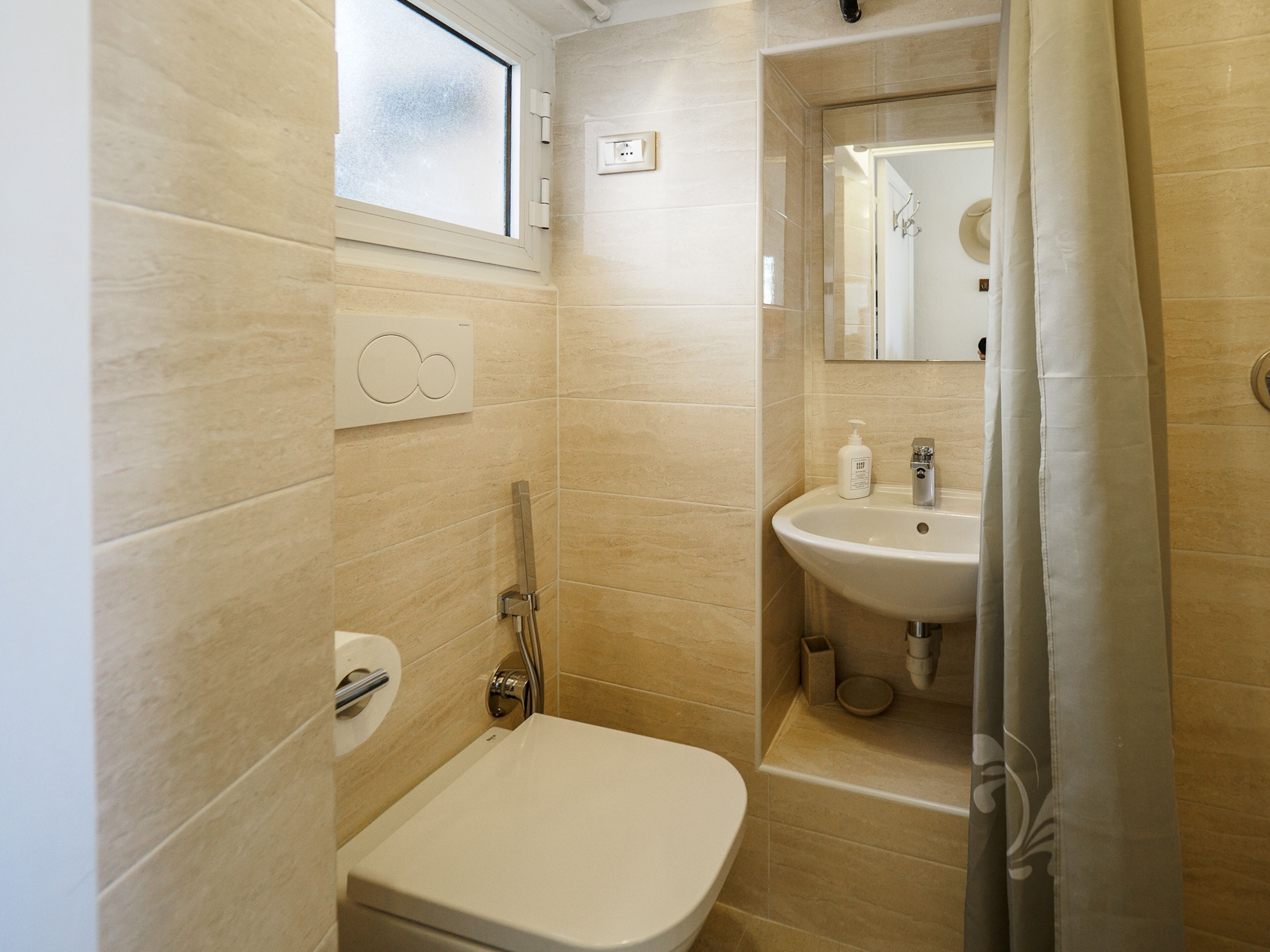 A bathroom with a toilet, sink, and shower.
