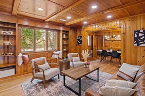A wooden interior with a dining area, sofas, and a table. - WATERFRONT!! HOT TUB!! 4 BED/4 BATH CHARMING HOME IN THE HEART OF CAMBRIDGE (Cambridge)