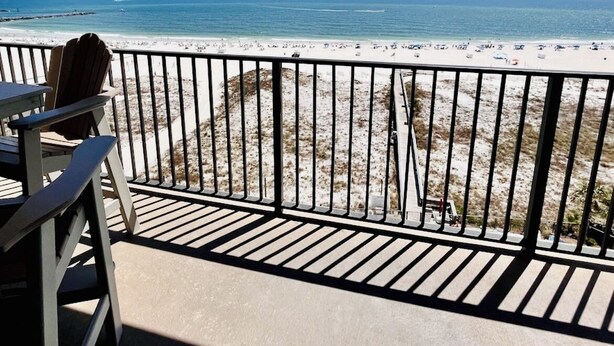 A balcony with a view of a beach and ocean.