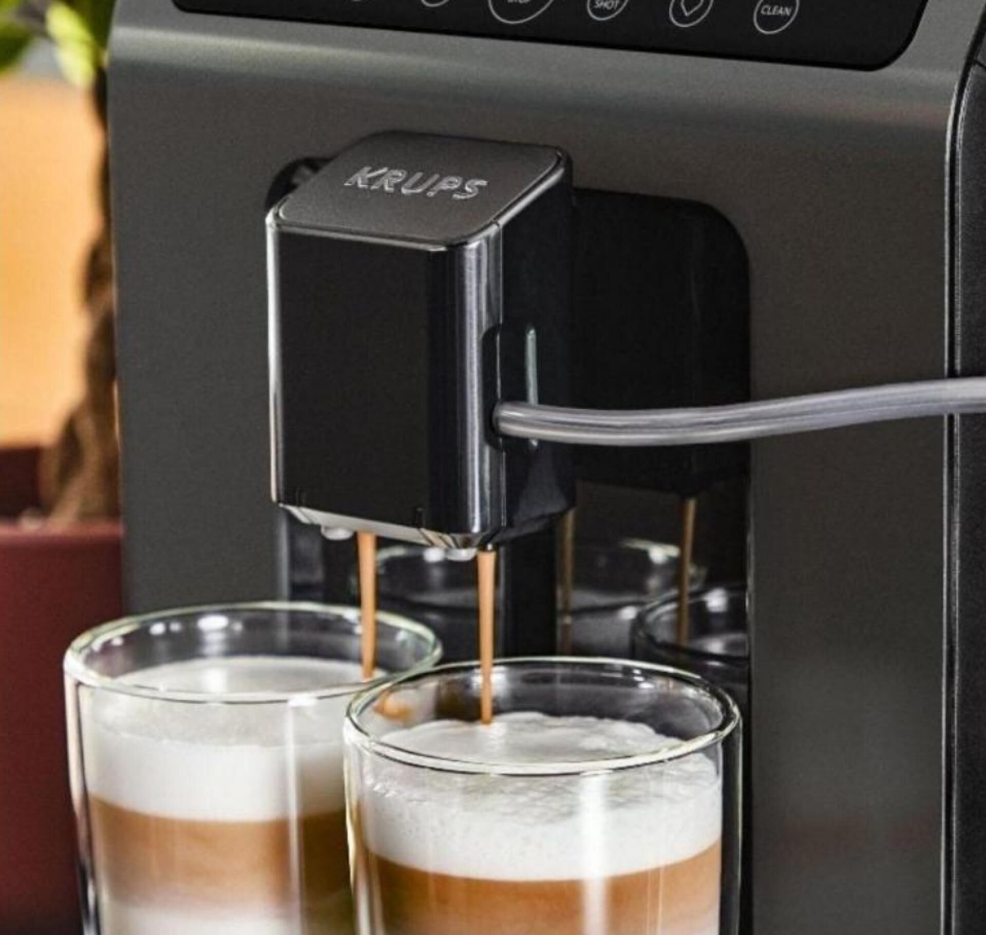 Una máquina de café Krups sirviendo café en dos vasos.