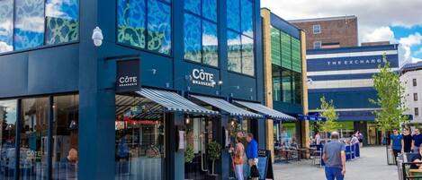 A modern building with large windows and a storefront labeled "COTE BRASSERIE".