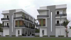 A modern multi-story residential building with balconies, a covered carport, and a flat roof.