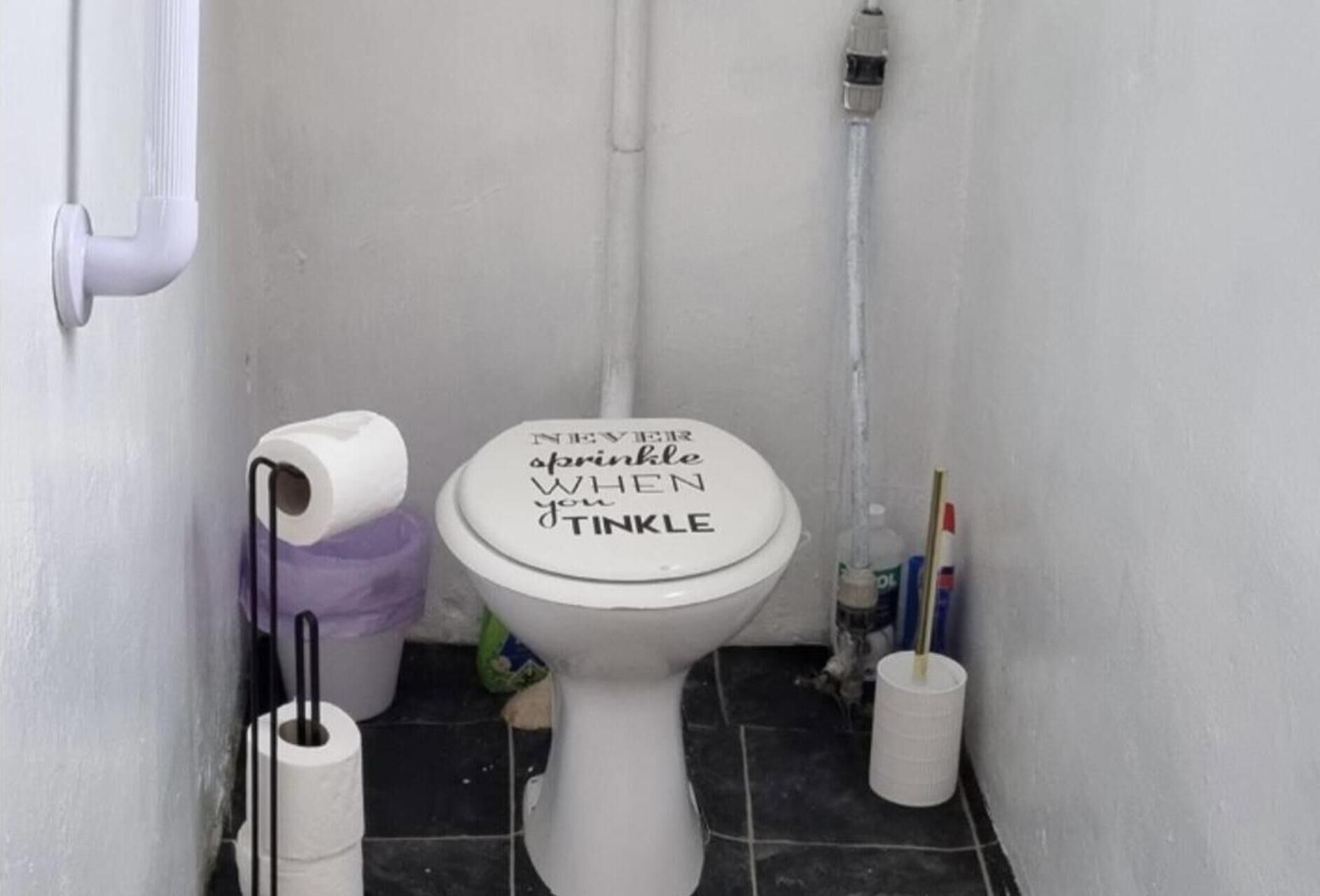 A toilet with a lid that reads "NEVER EVER apopkinle WHEN youTinkle".