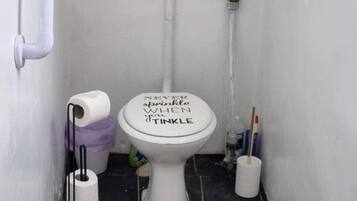 A toilet with a lid that reads "NEVER EVER apopkinle WHEN youTinkle".