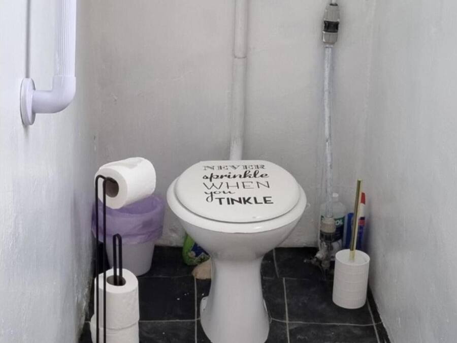 A toilet with a lid that reads "NEVER EVER apopkinle WHEN youTinkle".