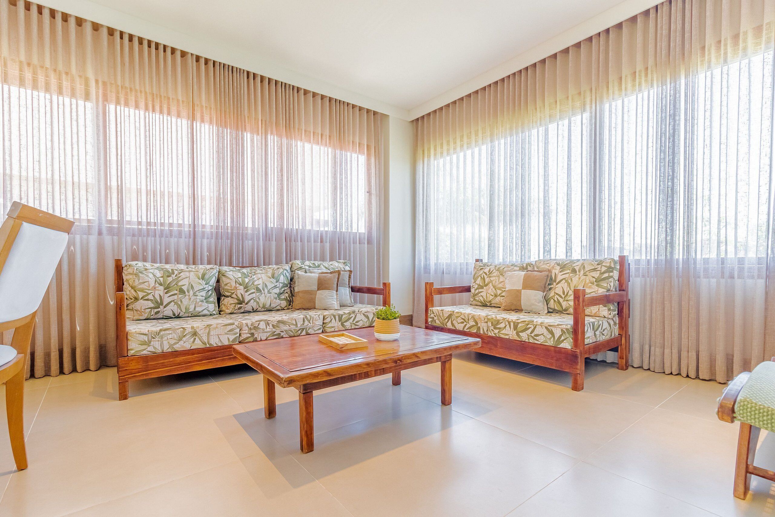 Sala de estar com dois sofás, uma mesa de centro e uma poltrona.