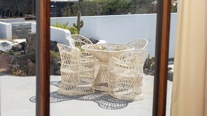A terrace with wicker furniture and a view of the city.