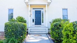 A white building with a dark blue door, white trim, and a small porch with steps. - Large colonial style house in the most sought after area - Ballantyne.  (Charlotte)