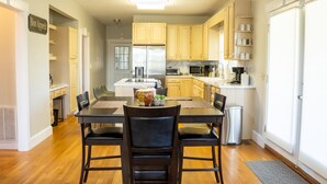 A modern kitchen with wooden cabinets, a central island, and a dining area with a table and chairs. - Large colonial style house in the most sought after area - Ballantyne.  (Charlotte)