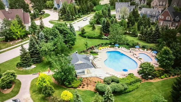 A residential area with a large swimming pool surrounded by well-maintained lawns and trees. - Newly renovated Blue Mountain condo in Historic Snowbridge (The Blue Mountains)
