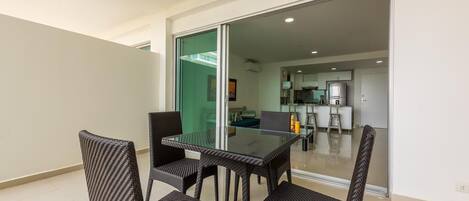 A modern living room with a glass door leading to a kitchen.