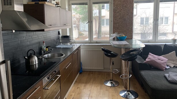 A modern kitchen with a stove, sink, and bar stools. - Big Apartment in Stockholm City (Stockholm)