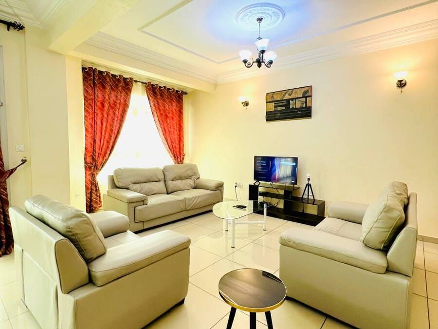 A living room with a sofa set, a coffee table, and a television.