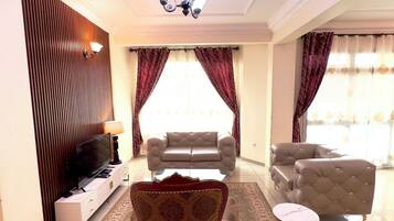 Apartamento Deluxe | Zona de estar | Televisión de pantalla plana de 43 pulgadas con canales por satélite