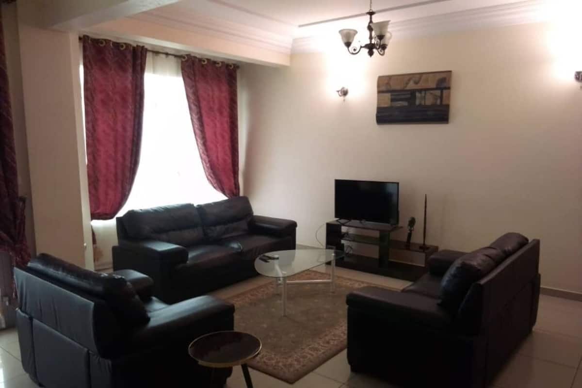 A living room with a sofa set, a coffee table, and a flat-screen TV.