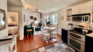 A compact kitchen with a dining area, a ceiling fan, and a skylight. - Cozy Cabin in Redwoods | Hot Tub (Guerneville)