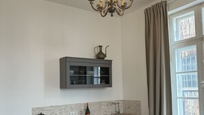 Een moderne keuken met een ingebouwde magnetron, een fles wijn en een koffieapparaat op het aanrecht.