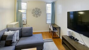 Un salon moderne avec un canapé, une table à manger et un téléviseur.