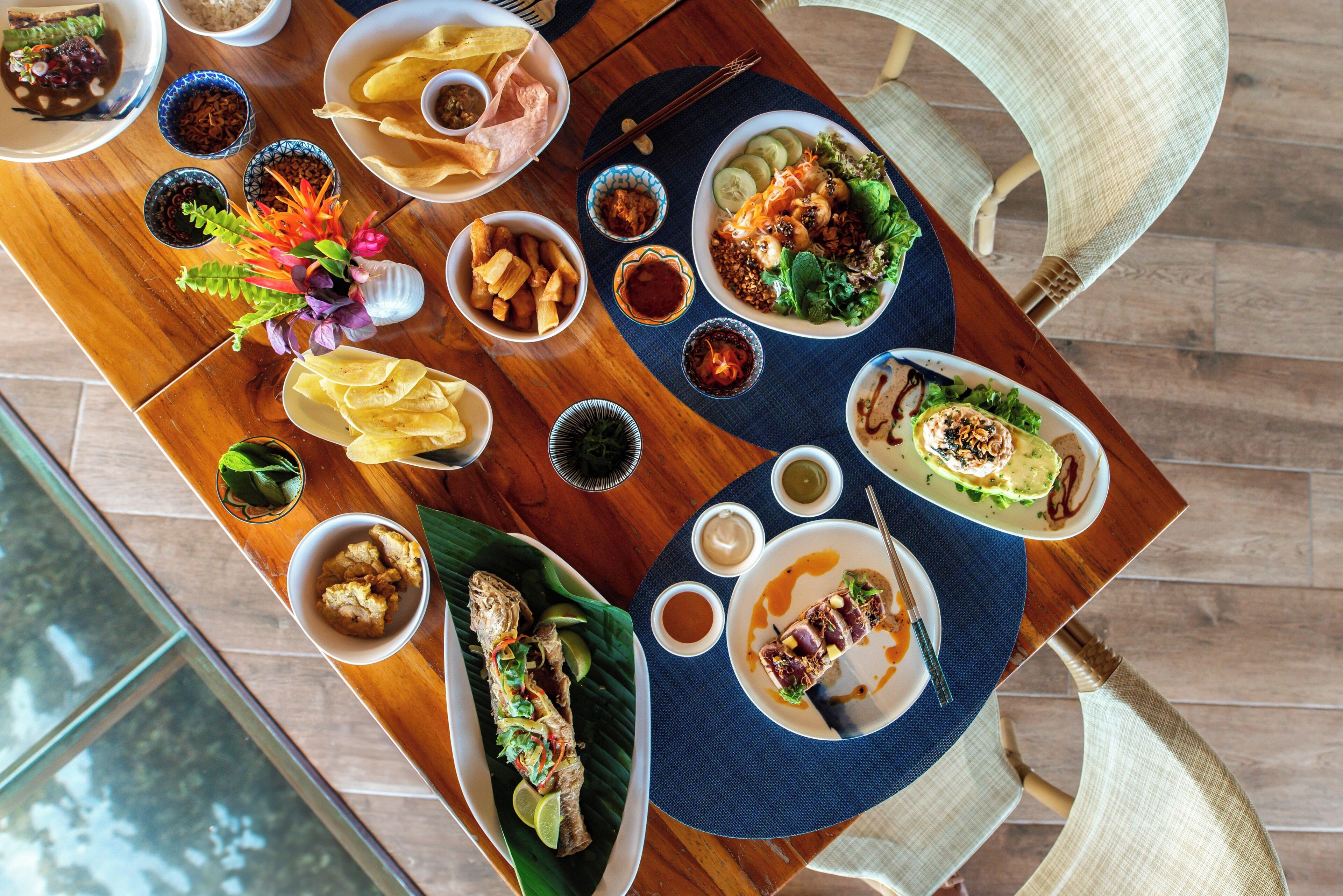 A dining table with various dishes, including a fish dish, salads, and sides.