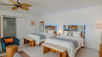A hotel room with two beds, a ceiling fan, a chair, a bench, and artwork on the walls.