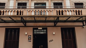 A building with a classical facade, a statue above the entrance, and a sign reading "ENTRADA". - MOSTEIRO Hotel de Charme (Garibaldi)
