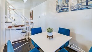 A dining area with a white table, blue chairs, and a potted plant. - Updated Arlington Townhome ~ 5 Mi to National Mall (Arlington)
