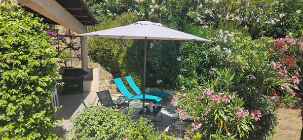 An outdoor patio with a table, chairs, and a large umbrella.
