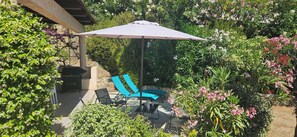 An outdoor patio with a table, chairs, and a large umbrella.