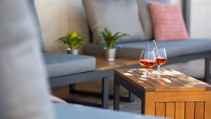 A wooden table with two glasses of red wine, a grey sofa with cushions, and a small potted plant. - Brand new 6 bedroom villa, only 1500m from the beach, village Valbandon (Valbandon)