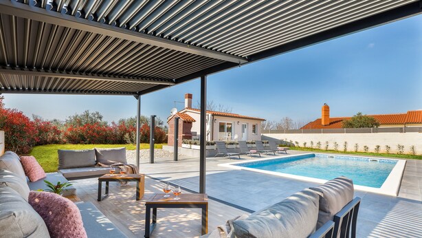A covered outdoor area with a pool, seating, and a view of a house in the background. - Brand new 6 bedroom villa, only 1500m from the beach, village Valbandon (Valbandon)