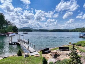 Un molo sul lago con un'area relax coperta e un braciere.