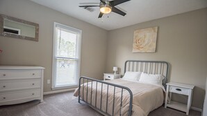 A bedroom with a bed, bedside tables, a dresser, a ceiling fan, a window with blinds, and a wall-mounted artwork. - Welcome!  The Darby House is named for Colonel William O Darby (Columbus)