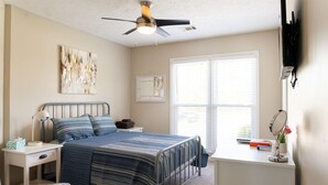 A bedroom with a bed, nightstand, desk, and a ceiling fan. - Welcome!  The Darby House is named for Colonel William O Darby (Columbus)