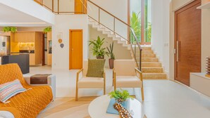 Un vaste espace de vie comprenant un escalier, un canapé et une table basse.