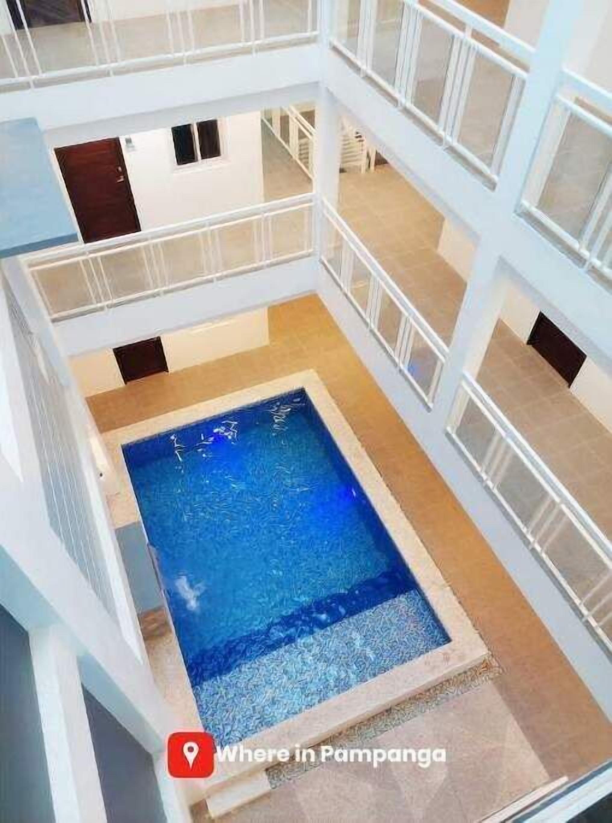 Ein mehrstöckiger Swimmingpool mit klarem, blauem Wasser, umgeben von weißen Geländern und einem gefliesten Boden.